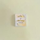 A close-up of an Elegant Chocolate Favour held in a hand, showcasing its professional packaging and glossy card.